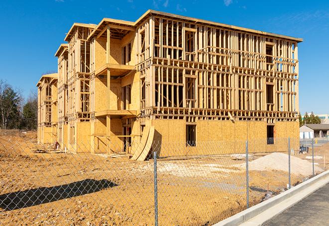 workers protected by temporary barrier fence during building maintenance in Redmond, OR